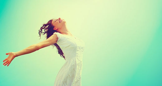 woman with outstretched arms facing the light