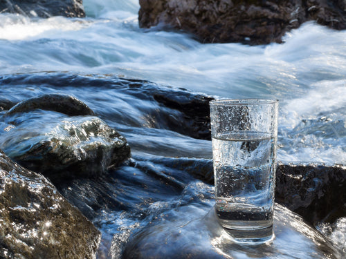 galss of water by a stream