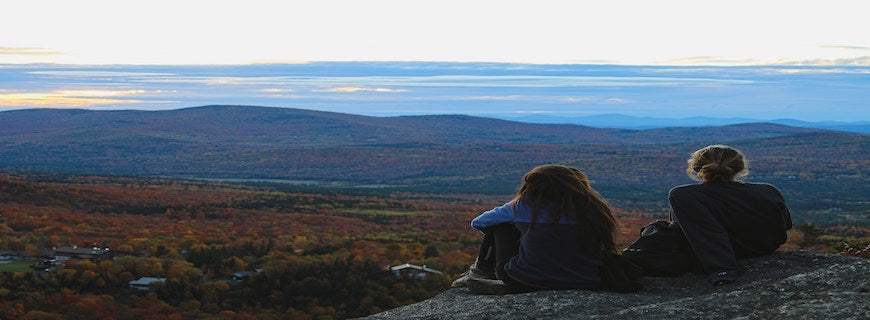 two women gazing over green landscape