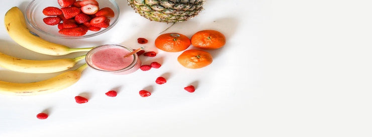 strawberries, tangerines, pineapple on white backdrop