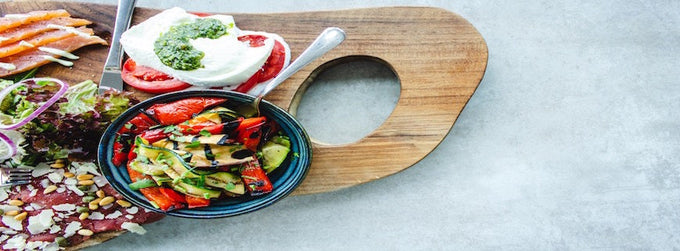 an array of healthy food on a wooden board: salad, salmon