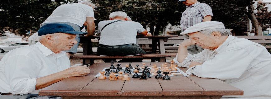 Two elderly men staring across a chess board at one another