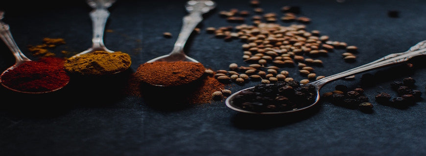 row of silver spoons containing spices