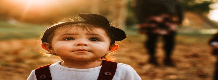 female toddler standing in the sun