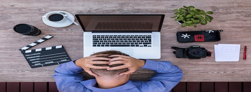 man at computer with hands on head