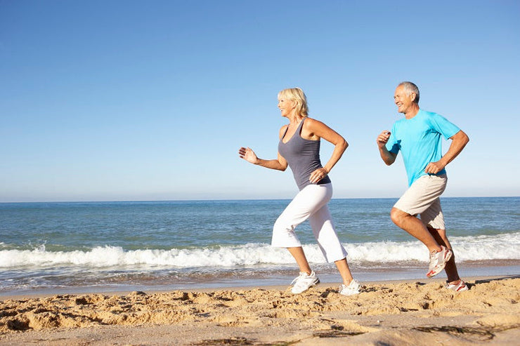 man and woman running on seashore