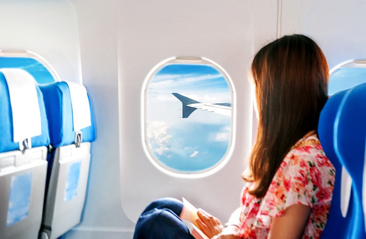 woman looking out of aeroplane window