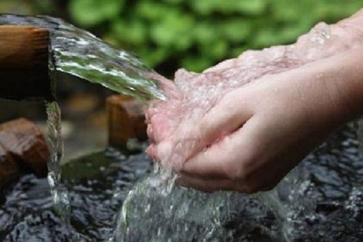 hands catching water from spring