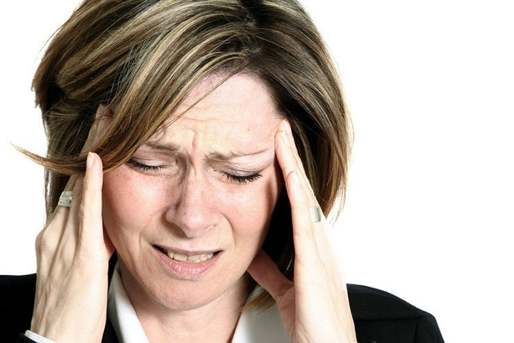 woman grimacing and holding her head