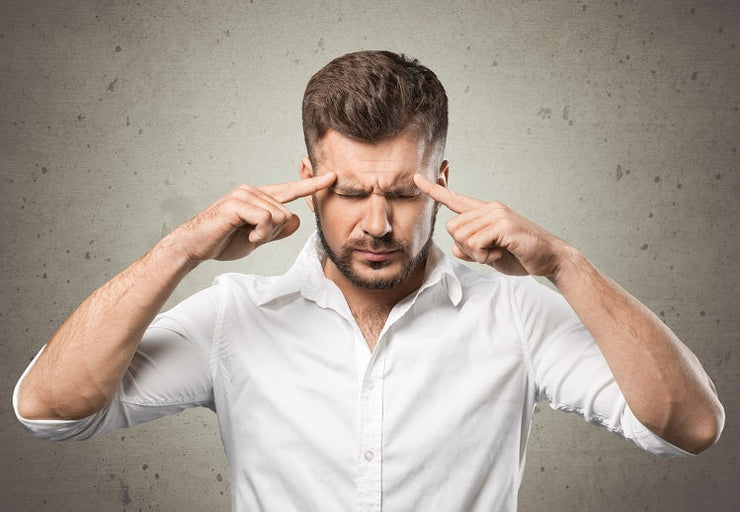 man with fingers pointing at forehead