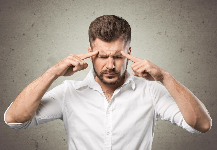 man with fingers pointing at forehead